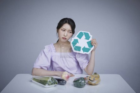 korean asain beautiful woman holding recycled fruit and vegetable labeling wrapped in zero-waste disposable wrap.