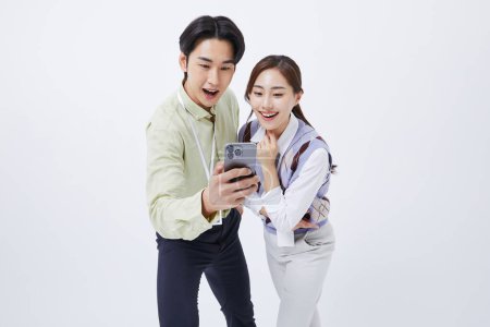 Un homme et une femme souriant à un smartphone