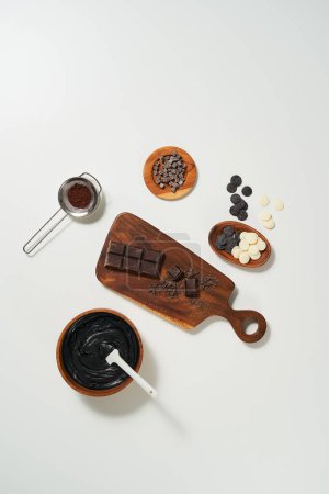 Chocolat fondu et divers types de chocolat sont servis sur des assiettes et planche à découper