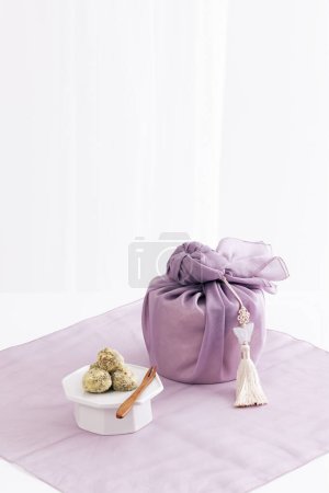 There is a rice cake next to the gift wrapped in a cloth