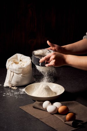 The process of sifting flour with both hands close-up view