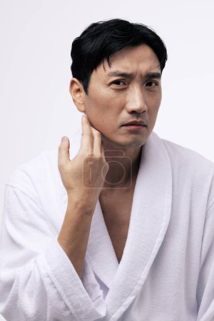 a middle aged man with a hand on his chin