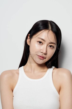 an Asian woman staring at the front of a white background