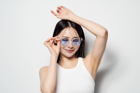Asiatische Frau posiert mit Sonnenbrille