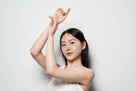 Asiatique femme pose en blanc haut sur fond blanc