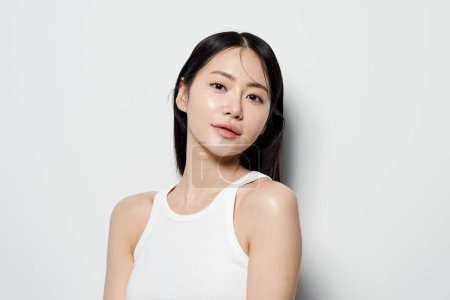 Mujer asiática mirando fijamente a la cámara contra fondo blanco