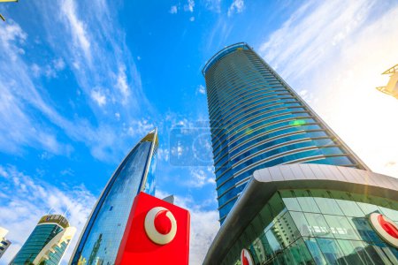Foto de Doha, Qatar - 17 de febrero de 2019: vista inferior del edificio de la sede central de Vodafone y la marca del logotipo en el área de Qatar West Bay, Oriente Medio. Vodafone es una multinacional de telefonía móvil y fija - Imagen libre de derechos