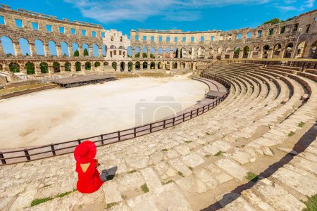 Tourist inside Pula Amphitheater or Coliseum of Pula is a well-preserved Roman amphitheater, located in Pula, Istria, Croatia. Ancient Roman empire arena constructed in 27 BC -68 AD