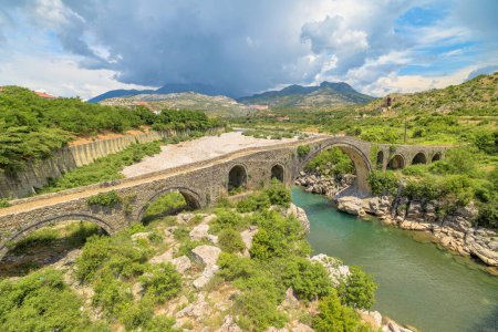 Téléchargez les photos : Vue par drone sur le pont Mesi, situé en Albanie, est un joyau architectural qui enjambe la rivière Kir dans le village pittoresque de Mesi. Ce pont historique en pierre, datant de la période ottomane. - en image libre de droit