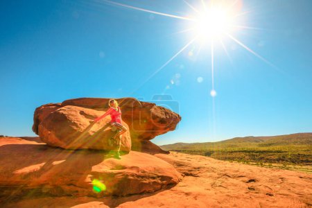 Téléchargez les photos : Femme touristique après trekking au sommet du belvédère Kalaranga avec des vues spectaculaires sur l'amphithéâtre en grès. Rayons de soleil dans le ciel bleu. Parc national Finke Gorge, Territoire du Nord, Australie centrale Outback. - en image libre de droit
