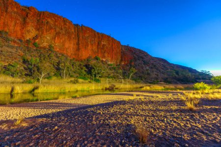 Téléchargez les photos : Glen Helen Gorge le soir avec un trou d'eau sur la rivière Finke. Tjoritja - West MacDonnell Ranges dans le Territoire du Nord, Australie. Outback australien le long de Red Centre Way, 130km à l'ouest d'Alice Springs. - en image libre de droit