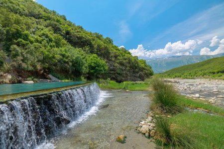 Foto de La piscina del puente de Kadiut está enclavada en exuberantes paisajes y cuenta con los relajantes sonidos de la naturaleza. Este oasis aislado ofrece un retiro pacífico del estilo de vida acelerado en Albania. - Imagen libre de derechos