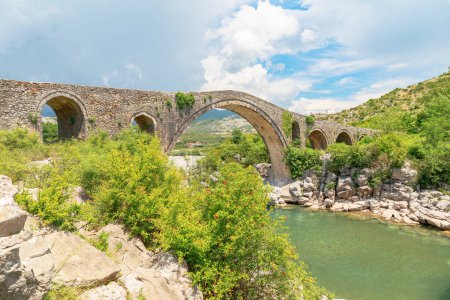 Foto de El Puente Mesi en Albania es un impresionante ejemplo de brillantez arquitectónica a través del río Kir en el encantador pueblo de Mesi. Este puente de piedra tiene una rica historia, que se remonta a la época del Imperio Otomano - Imagen libre de derechos
