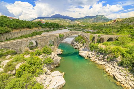 Foto de Histórico Puente Mesi en Albania. los visitantes se maravillan de su exquisita belleza, se sumergen en un pintoresco entorno natural y honran el rico patrimonio de este hito histórico. vista aérea - Imagen libre de derechos