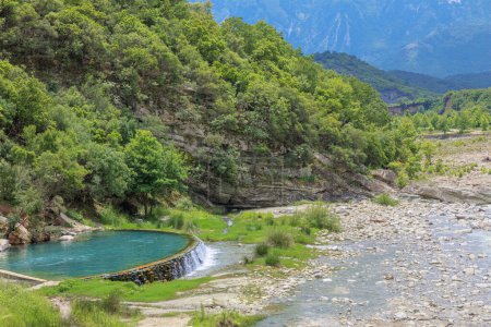 Foto de Puente de Kadiut piscina natural en Albania es un verdadero santuario de paz y esplendor natural. Sus aguas cristalinas y sus impresionantes alrededores invitan a todos los viajeros a disfrutar de una experiencia revitalizante. - Imagen libre de derechos
