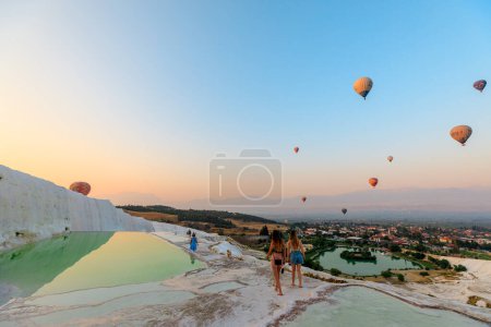 Foto de Pamukkale, Turquía - Aug 7,2023: Los visitantes de Pamukkale pueden caminar descalzos en las terrazas, donde el agua cálida y cargada de calcio crea piscinas y cascadas poco profundas, que se asemejan al algodón esponjoso.. - Imagen libre de derechos