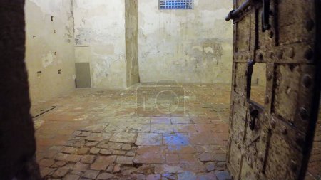 Photo for Dungeons of Ferrara Castle in Italy, were dark cells where enemies of Este family were imprisoned and tortured. Walls were covered with graffiti and stains, and air was filled with screams and moans. - Royalty Free Image