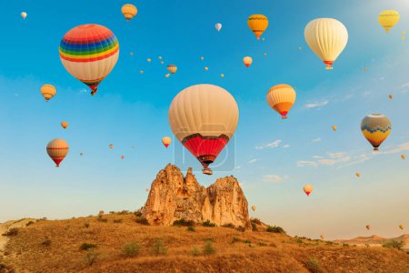 Al amanecer en Turquía, los globos aéreos de Capadocias llenan el Valle de las Rosas de Goreme con una colorida y encantadora exhibición, una armoniosa fusión de la belleza de la naturaleza y la innovación humana para viajes turísticos.