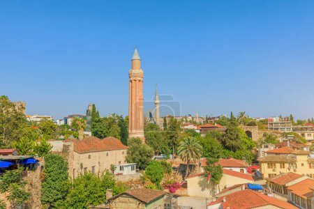 Téléchargez les photos : Antalya paysage urbain, Turquie, avec une mosquée et ses minarets distincts comme point focal. Les minarets, fabriqués à partir de briques rouges, présentent des dessins complexes. Charme architectural de cette ville côtière. - en image libre de droit