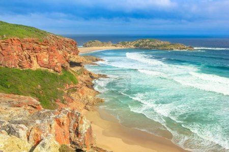Panorama from the cliffs of Robberg Nature Reserve, Plettenberg Bay, South Africa. Beach, waves and seal colony on the horizon. Copy space.
