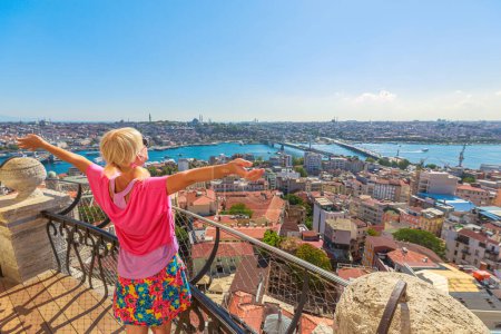 Vue arrière d'une femme à bras ouverts profitant du paysage urbain panoramique d'Istanbul d'un point de vue élevé par une journée ensoleillée d'Istanbul en Turquie