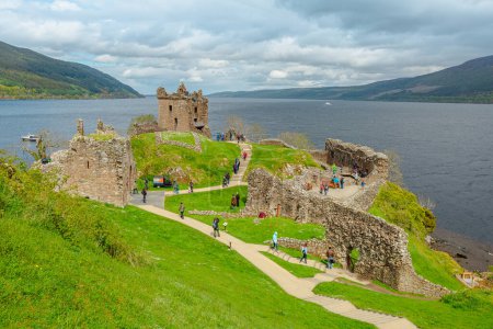 Photo for Loch Ness, Scotland, United Kingdom - May 24, 2015: aerial view of tourists visiting Urquhart Castle beside Loch Ness lake. Visited for the legend of the Loch Ness monster: Nessie. - Royalty Free Image