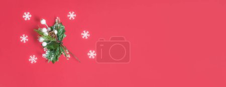 Foto de Rama de árboles, bayas y copos sobre fondo rojo. Composición de pancarta plana mínima, concepto de decoración de Navidad y Año Nuevo con espacio para copiar - Imagen libre de derechos