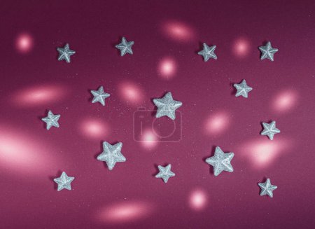 Foto de Estrellas decorativas plateadas y círculos de luz sobre fondo rojo oscuro. Composición de patrón plano mínimo, Cristmass abstracto y concepto decorativo retro estético de Año Nuevo - Imagen libre de derechos