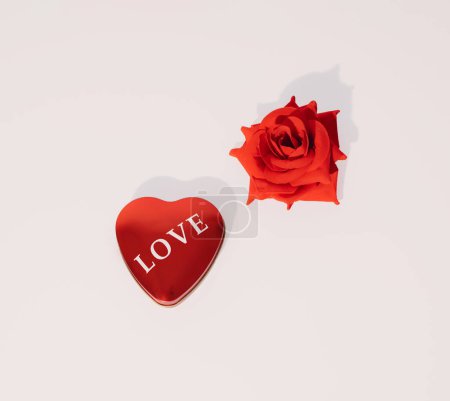 Foto de Heart shaped Love giftbox and rose on white background. Minimal square composition, romantic Valentines or International Women's day celebration concept - Imagen libre de derechos