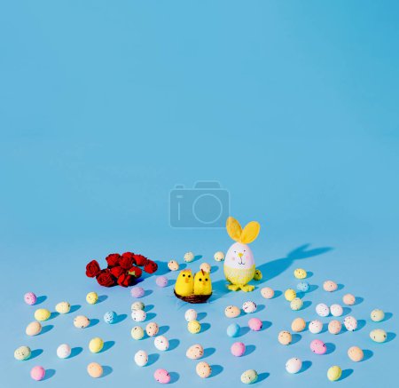 Foto de Easter Chickens, eggs and res roses on cyan background. Minimal - Imagen libre de derechos