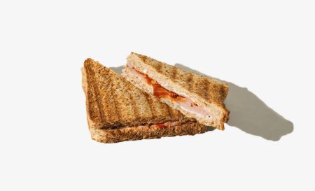 Foto de Sandwich tostado cortado por la mitad sobre fondo blanco. Composición horizontal mínima, concepto casero de comida rápida - Imagen libre de derechos