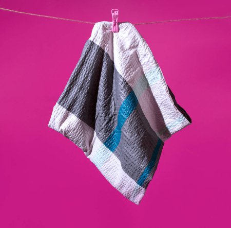 Foto de Pasador de ropa y funda de almohada colgando de una cuerda sobre un fondo púrpura. Composición horizontal mínima, concepto de ensueño colorido - Imagen libre de derechos