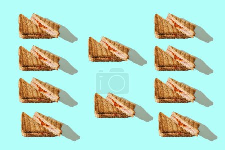Foto de Sandwiches tostados sobre fondo cyan. Composición horizontal mínima, patrón sin costuras, cono casero de comida rápida - Imagen libre de derechos