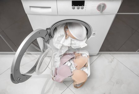 Foto de Lavando un sujetador en una lavadora. Hay una cubierta para ropa de cama. - Imagen libre de derechos