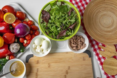 Foto de Mezcla de hojas de ensalada y verduras frescas. Bodegón en la mesa de la cocina. - Imagen libre de derechos