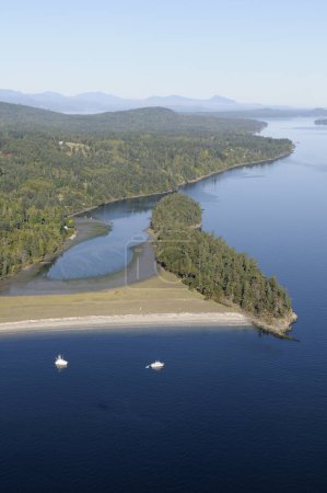 Boats at anchor in front of the white beach at Walker Hook, Salt Spring Island, British Columbia, Canada