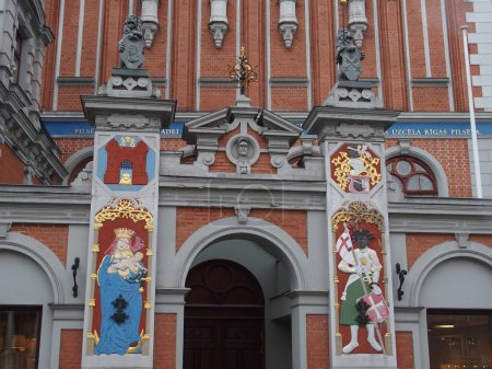 Téléchargez les photos : Détails colorés sur la façade de la Maison des points noirs à Riga, Lettonie : à gauche Marie et le Christ Enfant, à droite le saint patron saint Maruritius - en image libre de droit