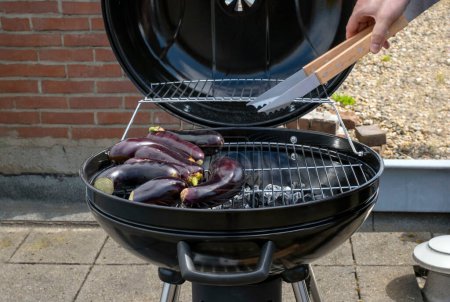 Black Compact Charcoal Grill Kettle with Fried Vegetables Stay on the Terrace, in garden or on the Roof Top.