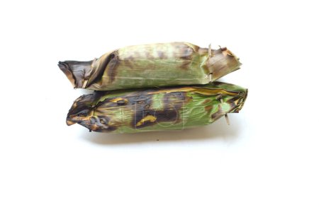 Foto de Alimento tradicional de Tailandia hecho de arroz pegajoso envuelto en hojas de plátano con taro y relleno de plátano y a la parrilla sobre un aislado de tortuga de carbón sobre un fondo blanco - Imagen libre de derechos
