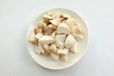 Téléchargez les photos : Vue de dessus et à plat déposer une huître royale crue champignons et rosmary (Pleurotus eryngii) dans une assiette blanche isolée sur un fond blanc, préparer la nourriture - en image libre de droit