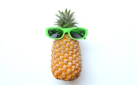 Téléchargez les photos : Vue de dessus et fermer l'ananas jaune dans des lunettes de soleil isolées sur fond blanc. Vue du dessus avec espace de copie.Été avec concept de fruits lunettes de soleil. - en image libre de droit