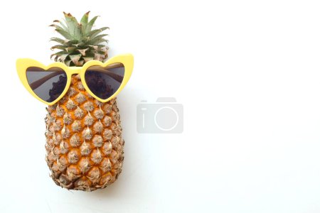 Téléchargez les photos : Vue de dessus et fermer l'ananas jaune dans des lunettes de soleil isolées sur fond blanc. Vue du dessus avec espace de copie.Été avec concept de fruits lunettes de soleil. - en image libre de droit