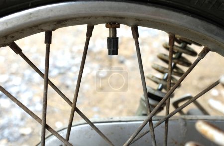 Photo for Close-up a Motorcycle tire valve,The air filler hole on the motorcycle wheel when the position is open,Tire Valve Stem with cap. black cap valve - Royalty Free Image