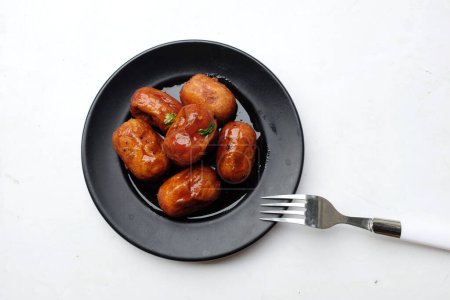 Téléchargez les photos : Mini cocktail de poulet rouge frit Saucisse en assiette isoler sur un placé sur un fond blanc. Un des barbecues thaïlandais savoureux couramment vu dans la nourriture de rue en Thaïlande. - en image libre de droit