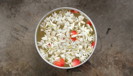 Photo for Close up a rose petals with jasmine flowers in a large silver bowl of water for bathing the buddha. for songkran festival or Thai New Year - Royalty Free Image