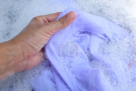 Photo for Hand of Asian housewife washing white clothes ,school uniform,Student uniforms with bubble detergent in basin.Laundry concept - Royalty Free Image