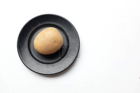 Téléchargez les photos : Tas de pommes de terre fraîches crues de bébé (Solanum tuberosum) tête ou jeune pomme de terre dans un plat en céramique isolé sur un fond blanc - en image libre de droit