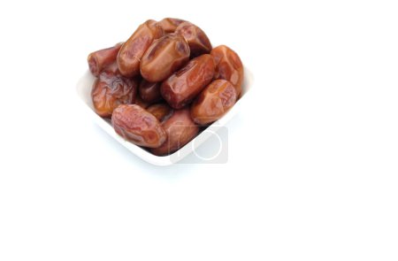 Photo for Heap of tasty dry dates or dates palm or palm phoenix dactylifera fruit in a white plate isolate on a white backdrop.snack healthy,arabic food, tropical fruit - Royalty Free Image