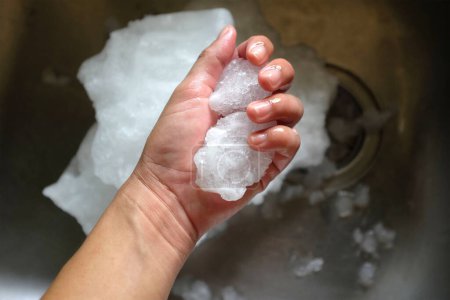Foto de Hielo del congelador en la palma de la mano mujer asiática de cerca - Imagen libre de derechos