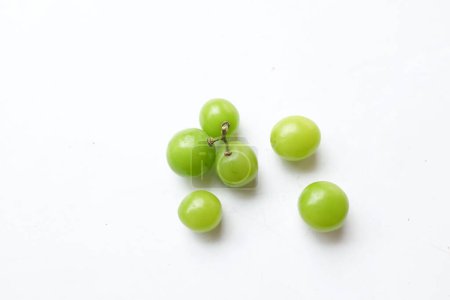 Téléchargez les photos : Une grappe de raisin frais Sweet Green Shine Muscat (Vitis vinifera) avec des feuilles isolées sur fond blanc. Raisin japonais. Raisin vert goût sucré croissance naturelle. - en image libre de droit